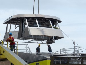 A cabin structure is lifted atop Salish Sea Dream