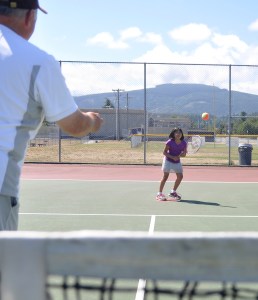 Nine-year-old Crystal Rieckhoff of Port Angeles gets instruction from tennis pro Don Thomas of Sequim at the Sequim High School tennis courts earlier this month. (Michael Dashiell/Olympic Peninsula News Group)