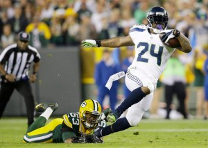 Seattle Seahawks' Marshawn Lynch is tripped up by Green Bay Packers' Nick Perry (53) during the first half of an NFL football game Sunday