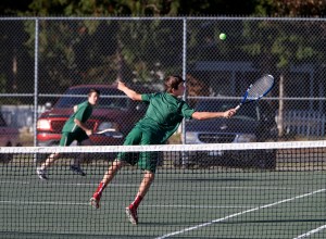 Port Angeles' Kenny Soule attempts a behind-the-back volley as doubles partner Zach Smith runs to back up the play during a match against Chimacum-Port Townsend at Chimacum High School on Monday. Steve Mullensky/for Peninsula Daily News