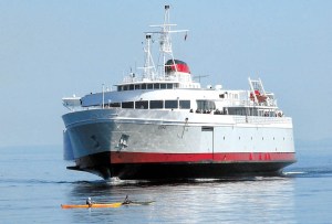 A pair of kayakers paddle in Port Angeles Harbor as the MV Coho approaches.  Keith Thorpe/Peninsula Daily News ()