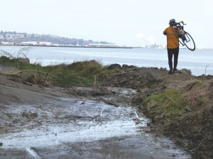 Bob Anundson carries his bike around a slide east of City Pier in Port Angeles.  Garland Frankfurth ()