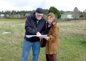 Spokesman Dennis Daneau shows Kay Harper the plans for the new Quimper Village senior co-housing development