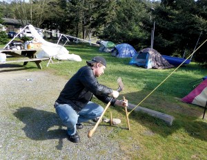 Levi Johnson hammers in the stakes to repair a tent that was blown down during a storm Monday night. Johnson is part of a small tent city in Fort Worden State Park.  Charlie Bermant/Peninsula Daily News ()