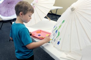 Tobin Reisenstahl decorates his umbrella prior to the 2015 RainFest umbrella parade in Forks. (Lonnie Archibald/for Peninsula Daily News)