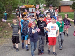 Brinnon Elementary School students wave the flag at the Loyalty Day Parade on Friday. The short parade celebrates patriotism and included 27 participants.  Charlie Bermant/Peninsula Daily News ()