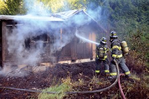 Clallam County Fire District No. 2 firefighters douse a structure fire at an employee housing unit near Lake Crescent Lodge on Tuesday evening. — Jay Cline/Clallam County Fire District No. 2 ()
