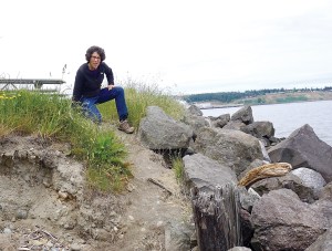 Jefferson County Marine Resources Committee Water Programs Coordinator Cheryl Lowe sits atop a bluff at Fort Towsend scheduled for removal this summer.  Charlie Bermant/Peninsula Daily News ()