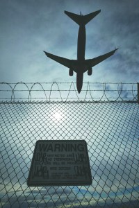 A sign warns against trespassing as a plane lands at McCarran International Airport in Las Vegas.  The Associated Press ()