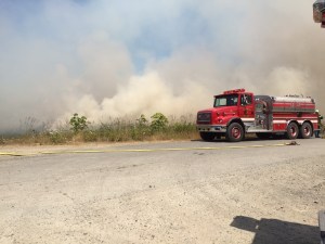 A Clallam County Fire District No. 2 truck sits beside the smoky fire that burned near the Elwha River this afternoon.  Photo by Jay Cline ()
