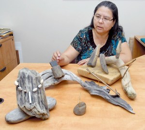 Lower Elwha Klallam Tribal Chairwoman Frances Charles examines a collection of artifacts from the Tse-whit-zen village site that will go on display today (Friday) at the Elwha Klallam Heritage Training Center in Port Angeles. Photo by Keith Thorpe/Peninsula Daily News