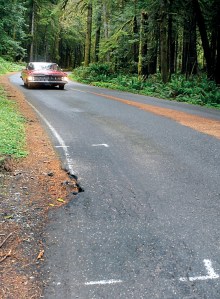 Paint outlines mark a spot of crumbling roadway as a car makes its way towards Lake Crescent Lodge and Bovees Meadow at Barnes Point on Lake Crescent in Olympic National Park last week.  Keith Thorpe/Peninsula Daily News ()