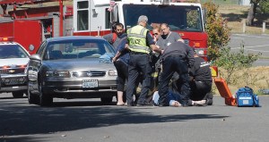 Police and paramedics assist a female pedestrian who was struck by a car at Ninth and G streets in Port Angeles on Wednesday.  Keith Thorpe/Peninsula Daily News ()