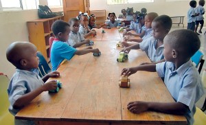 Children in a Haitian preschool play with wooden cars built from scratch by Larry Laing of Sequim. The cars were distributed by the Free the Children charity April 6. Free the Children