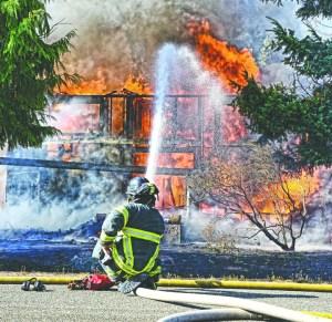Firefighters from Clallam County Fire District No. 2 battle a blaze at 21 Whispering Firs Road off Lower Elwha Road west of Port Angeles on Thursday. Jay Cline/Clallam County Fire District No. 2