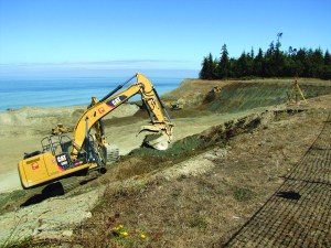 Crews on Thursday grade the closed Port Angeles landfill area where garbage was moved away from the bluffs overlooking the Strait of Juan de Fuca. — Arwyn Rice/Peninsula Daily News