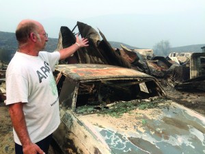 Steve Surgeon surveys the ruins Sunday after he lost everything he owned except his home in a wildfire on the outskirts of Okanogan.  The Associated Press