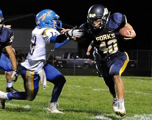 Forks running back Garrison Schumack (40) avoids the tackle of Rochester's Joumey Fortner (12). Lonnie Archibald/for Peninsula Daily News