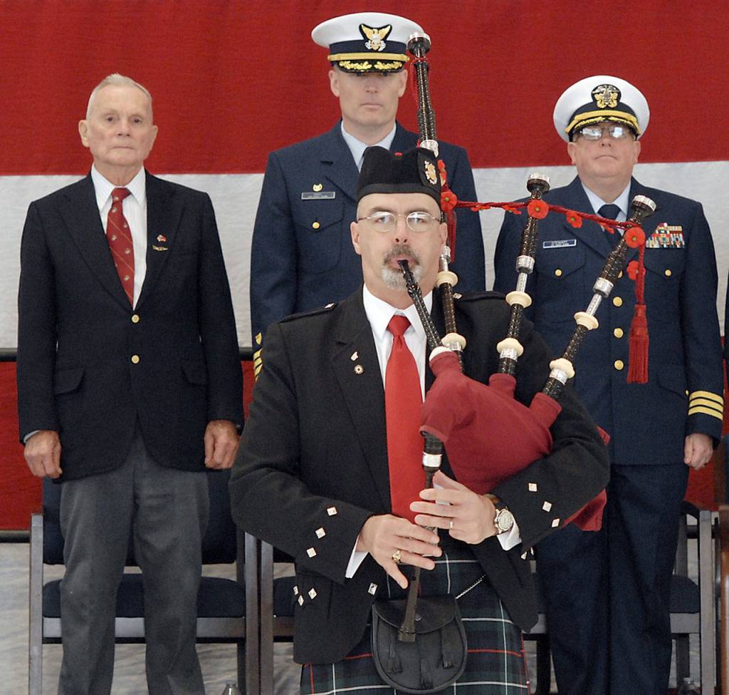 Bagpiper Rick McKenzie, a retiree from the U.S. Coast Guard, plays Amazing Grace to help close out Saturdays Veterans Day ceremony. On the podium behind were, from left, retired U.S. Marine Corp Col. Thomas Johnson, Capt. Mark Hiigel, commanding officer of U.S. Coast Guard Air Station/Sector Field Office Port Angeles, and Coast Guard District 13 Chaplain Cmdr. William Stuart. (Keith Thorpe/Peninsula Daily News)