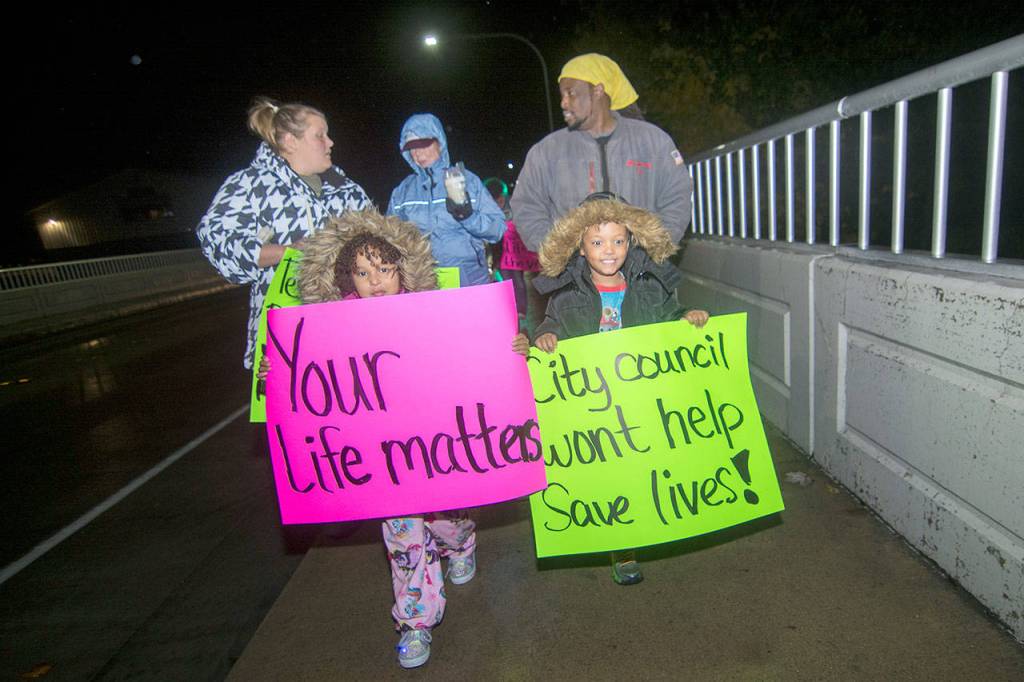 Protesters took to the Eighth Street bridges Monday night, calling on the city of Port Angeles to add taller fences to the spans. (Jesse Major/Peninsula Daily News)