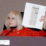 Port Angeles Deputy Mayor Cherie Kidd holds up a notebook containing an obituary for Ashley Wishart, who died after jumping from the eastern Eighth Street bridge Nov. 13. Kidd is working with state representatives to fund taller barriers for the Eighth Street bridges. (Rob Ollikainen/Peninsula Daily News)