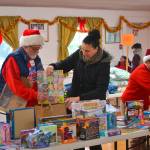 Volunteers Joel Ogden and Anne Notman with Sequim Community Aid help Sheena Touchard, right, look for toys at last years Toys for Sequim Kids. Organizers said 400 children in Sequim received items from the event in 2016. This year, the event is set for Dec. 13 at the Sequim Prairie Grange. (Matthew Nash/Olympic Peninsula News Group)