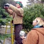 Willow Hundtoft hands ornaments to Tara Homeyer to help decorate the Christmas tree in downtown Port Townsend. The two were part of a handful of volunteers who braved the rain to help decorate the tree Tuesday. (Cydney McFarland/Peninsula Daily News)