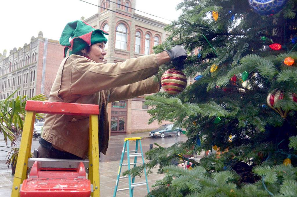 Tara Homeyer helps decorate the Christmas tree in downtown Port Townsend on Tuesday. (Cydney McFarland/Peninsula Daily News)