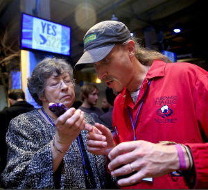 State Sen. Maralyn Chase shows the first election results of I-522 to Dr. Bronner's Magic Soap CEO David Bronner during the Yes on I-522 campaign party in Seattle's Pioneer Square neighborhood Tuesday