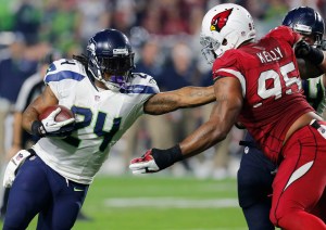 Seattle Seahawks running back Marshawn Lynch (24) fights through Arizona Cardinals defensive end Tommy Kelly (95) on his touchdown run in the first half of Seattle's 35-6 win on Sunday. The Associated Press