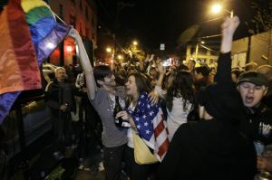 Revelers display U.S. and gay pride flags in Seattle as they celebrate early returns favoring Referendum 74 on Tuesday night.