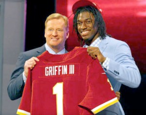 Robert Griffin III from Baylor holds up a Washington Redskins jersey as he stands on stage with NFL Commissioner Roger Goodell after Griffin was selected No. 2 overall by the Washington Redskins in the first round of the 2012 NFL Draft. The Associated Press