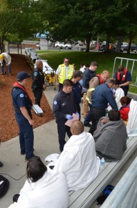 Members of Clallam County Fire District No. 3 and Olympic Ambulance evaluate canoe pullers from Vancouver Island at John Wayne Marina in Sequim after they were rescued from the water off Port Townsend on Monday morning.  -- Photo by Patrick Young/Clallam County Fire District No. 3