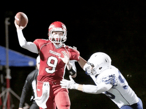Erik Lind of Marysville Pilchuck attempts a pass as Meadowdale's Garrett Walsh goes for the sack Friday night at Quil Ceda Stadium in Marysville. The (Everett) Herald