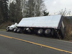 Power was shut off Wednesday for 132 Joyce customers as a safety measure while this truck was pulled from a ditch near Gossett Road west of Joyce on state Highway 112. Greg Waters/Clallam Fire District 4