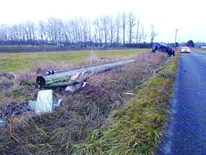 A Clallam County sheriff's deputy watches over a black Hummer SUV that knocked over a power utility pole on Woodcock Road west of Kitchen-Dick Road near Sequim on New Year's morning around 7 a.m.