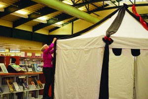 Staffer Karen Kilgore raises the big tent at the Port Angeles Library on Saturday