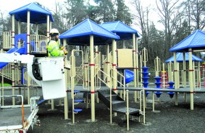 Port Angeles Parks Department employee Darryl Anderson installs new playground equipment at Shane Park in Port Angeles. Keith Thorpe/Peninsula Daily News