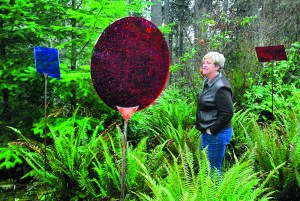 Port Angeles Fine Arts Center executive director Robin Anderson walks through a portion of the restored art installation "Linger" by Seattle artist Carolyn Law in the Webster's Woods outdoor art park on Thursday. Keith Thorpe/Peninsula Daily News