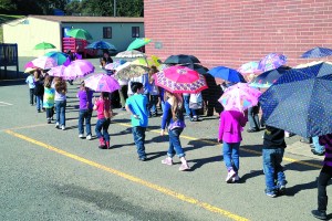 Kindergartners at Hamilton Elementary take the traditional Umbrella Walk on the first day of spring in 2012. The Port Angeles school and Neah Bay Elementary were the only two on the North Olympic Peninsula to be awarded A's by the Washington Policy Center. Peninsula Daily News