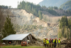 Rescue workers remove one of a number of bodies from the wreckage of homes destroyed by a mudslide near Oso. The Associated Press
