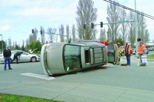 A Toyota Sienna van lies on its side Monday afternoon folllowing a collision in Port Townsend. Charlie Bermant/Peninsula Daily News