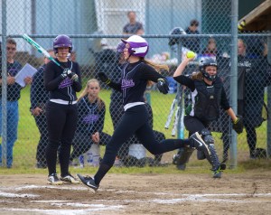 Quilcene's Megan Weller crosses home plate after a wild pitch as teammate Allison Jones