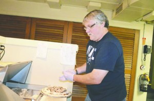 Brickhouse Bistro owner Kirk Stott pulls a pizza out of the oven