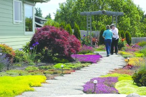 Two members of the Jefferson County Master Gardeners preview one of seven home gardens on today's Port Townsend Secret Garden Tour. Tickets are required to find the locations of the gardens on the tour.