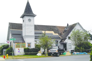 A crew from EarthTech Construction & Roofing replaces a section of roof on the Serenity House Thrift Store at First and Vine streets in Port Angeles on Tuesday. Keith Thorpe/Peninsula Daily News