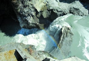 Water from the Elwha River flows over what remains of Glines Canyon Dam. The structure should be completely gone by early next summer.  -- Photo by Keith Thorpe/Peninsula Daily News