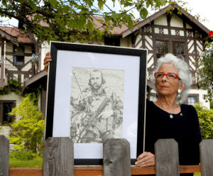 Betsy Reed Schultz holds a pencil drawing by Justin Schafer of Schultz's late son