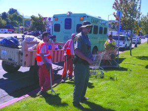 Clallam County corrections officer Nate Clark leads jail inmates in a cleanup of illegal campsites on Front Street at Estuary Park on Aug. 21. Brian Smith/Port Angeles Police Department