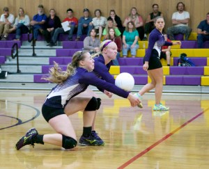 Quilcene's Megan Weller goes low and gets her wrists on the ball for a return as teammate Katie Bailey is there to back her up and Sammy Rae